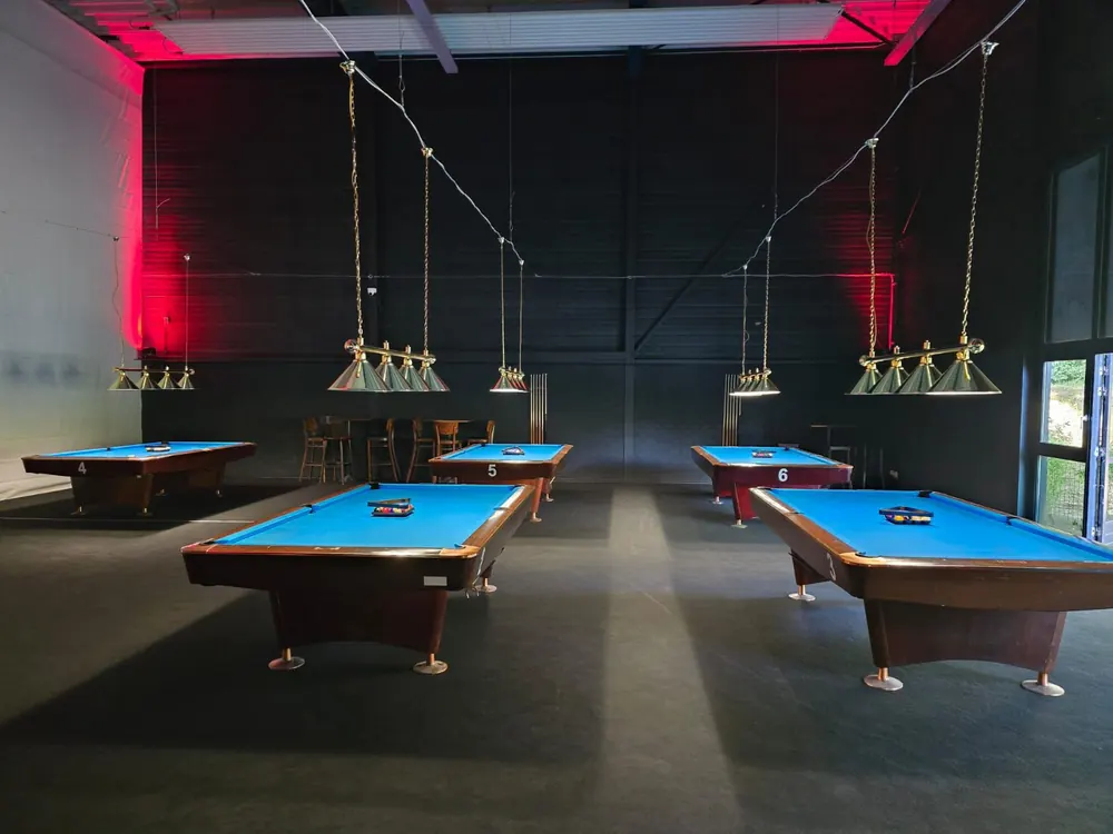 Billardhalle im XXL Sportcenter Duisburg mit nummerierten Pool-Tischen und Messinglampen darüber
